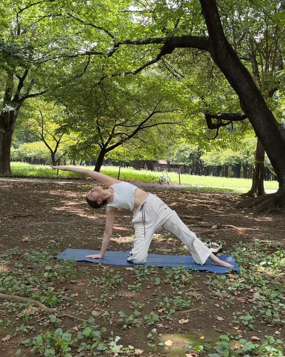 公園の木の下でヨガをするyoco